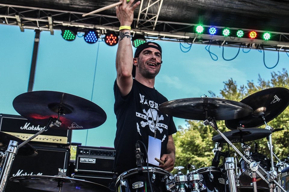 Drummer Jeffrey Hafer poses with Scorpion Percussion drumsticks behind his drumkit