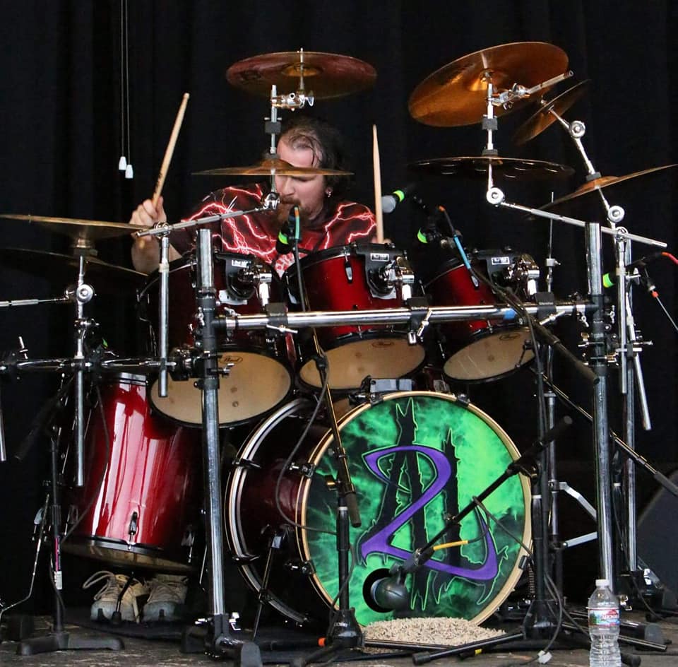 Drummer James Laughter poses with Scorpion Percussion drumsticks behind his drumkit