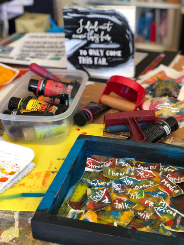 cluttered workshop table with paints and art