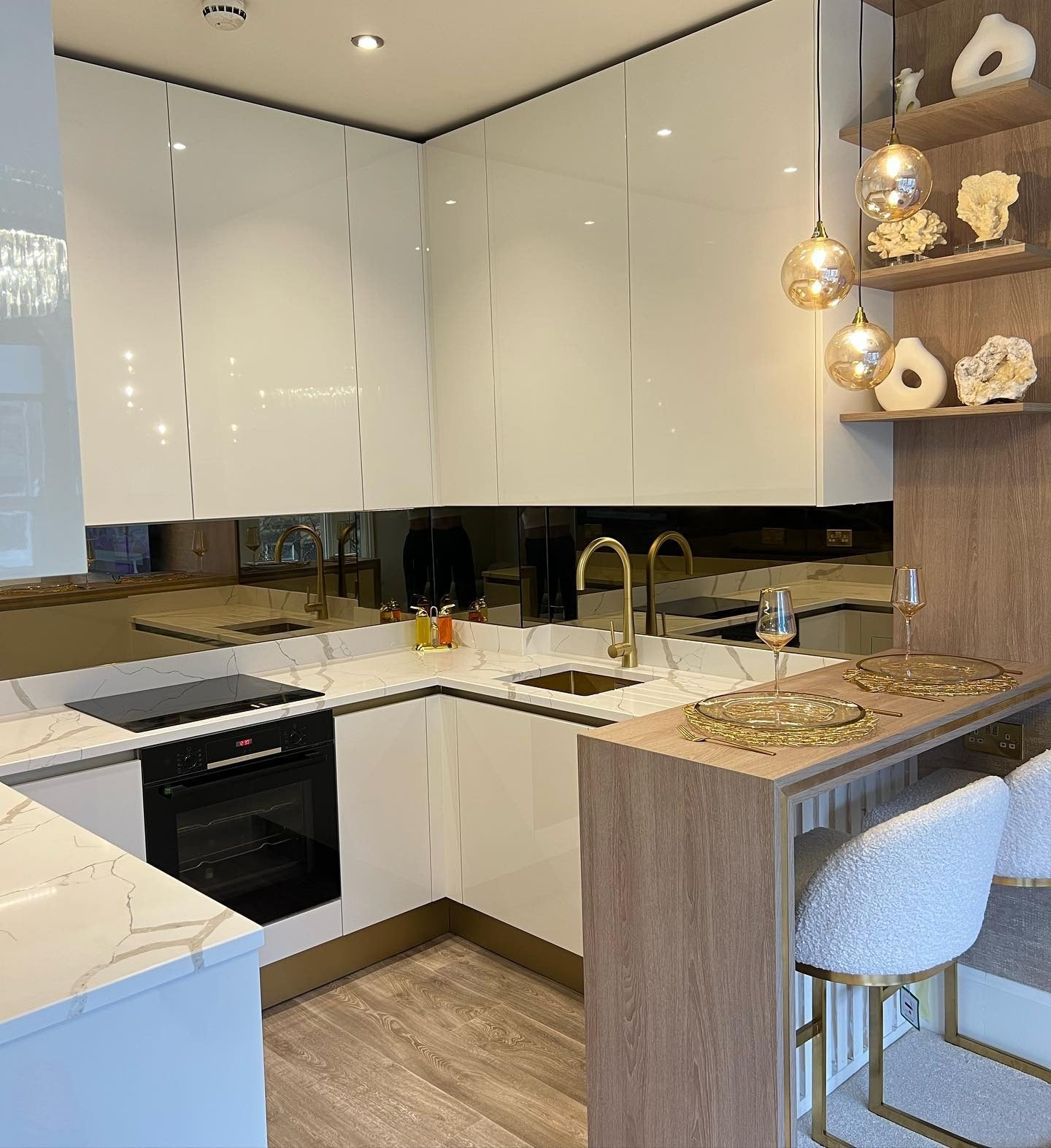 11. Glossed Modern Chic with Sculptural Brass - White and Gold Kitchen Ideas