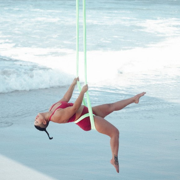 Person doing aerial yoga at the beach