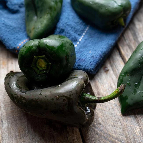 image of dark green poblano peppers on a countertop