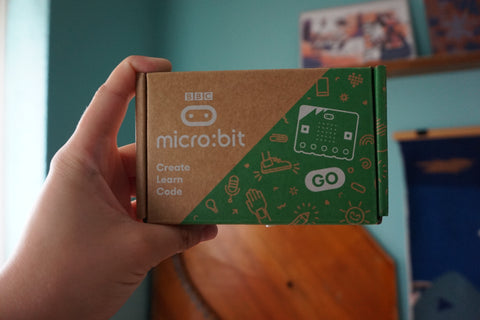 hand holding the micro:bit box in the air