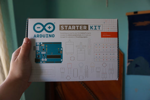 hand holding up an Arduino Starter Kit box