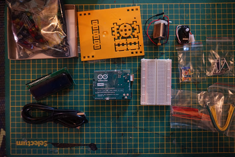 contents of the Arduino Starter Kit laid out on a green cutting matt