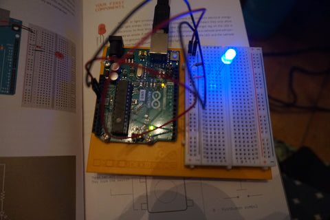 Mounted Arduino and breadboard with a simple circuit set up for a single lit up blue LED