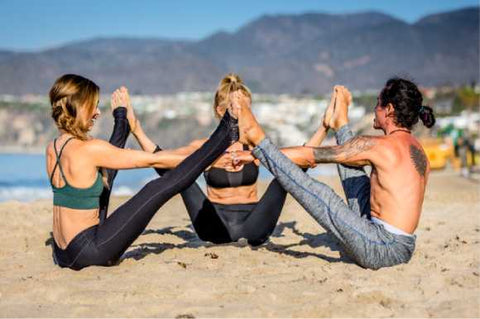 Friends in yoga pose on beach