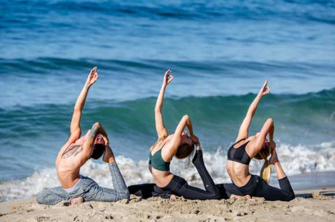 Friends on beach yoga pose