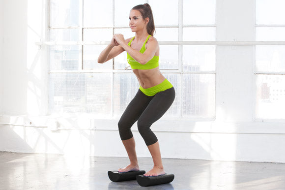 fit woman doing balancing exercise on prosourcefit high density half foam rollers
