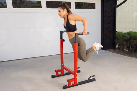 Woman doing tricep dips on a red power dip station