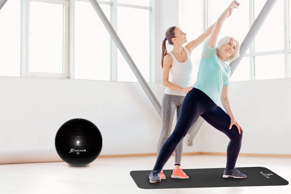 elderly woman stretching on prosourcefit yoga mat with prosourcefit stability ball