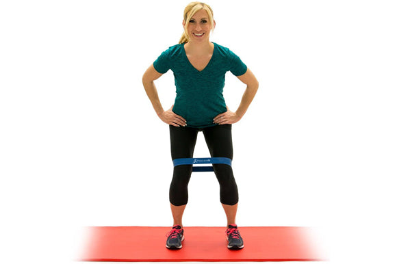 woman using prosourcefit loop resistance band on prosourcefit extra thick yoga and pilates mat for side step exercise