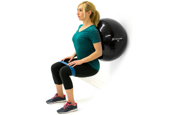 woman lowering into seated position while leaning against prosourcefit stability ball