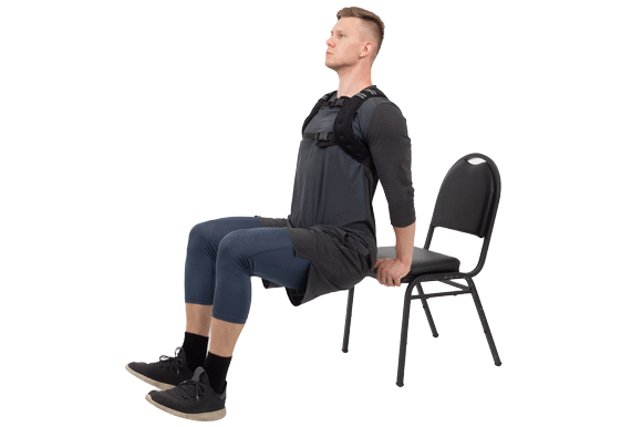 man doing dips with chair wearing prosourcefit weighted vest