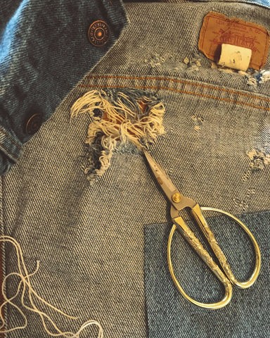 Materials for sashiko repair - denim jacket, thread, needle, thimble and scissors