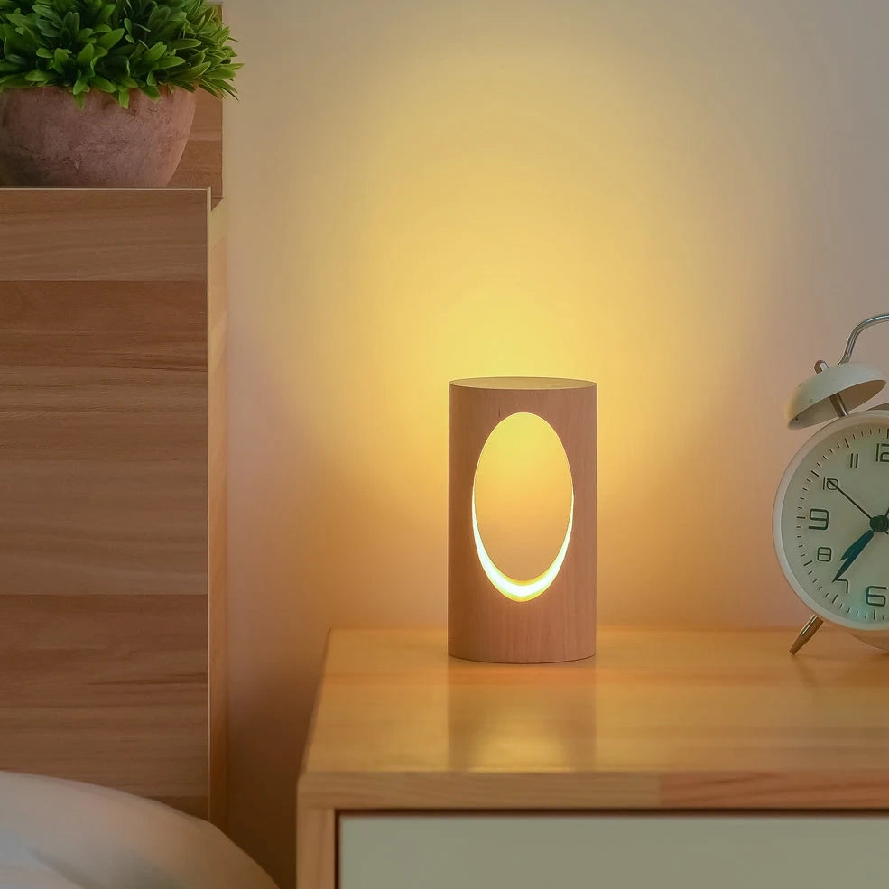 Solid wood LED reading lamp with adjustable arm and glass holder on wooden surface