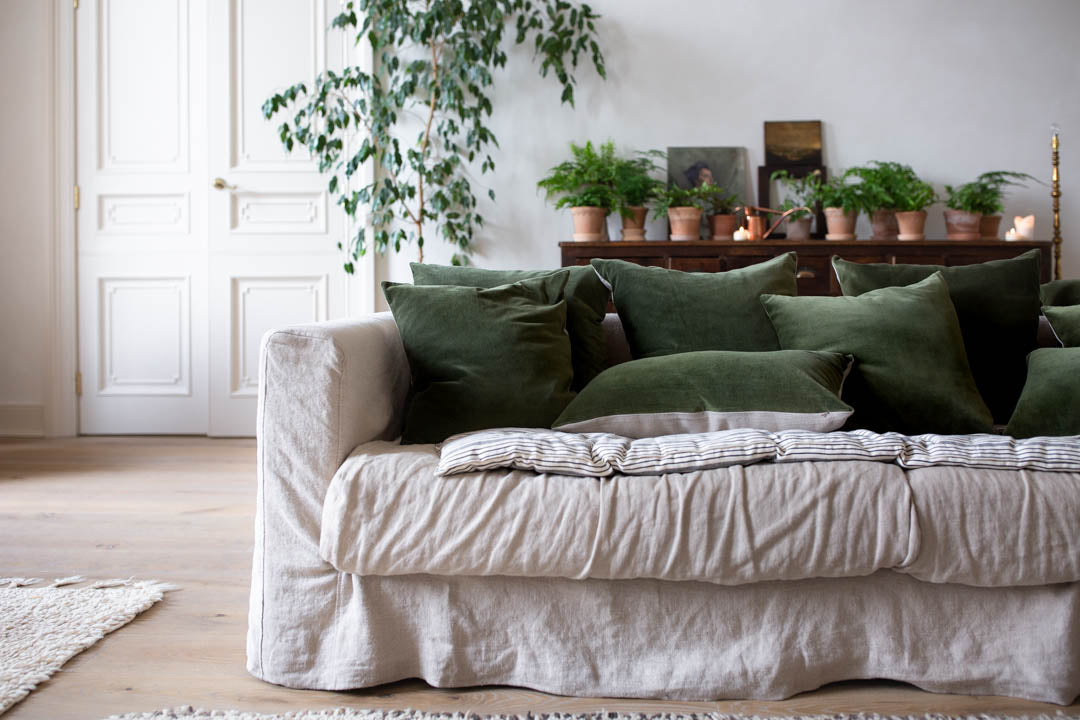 natural linen sofa with green velvet cushions 