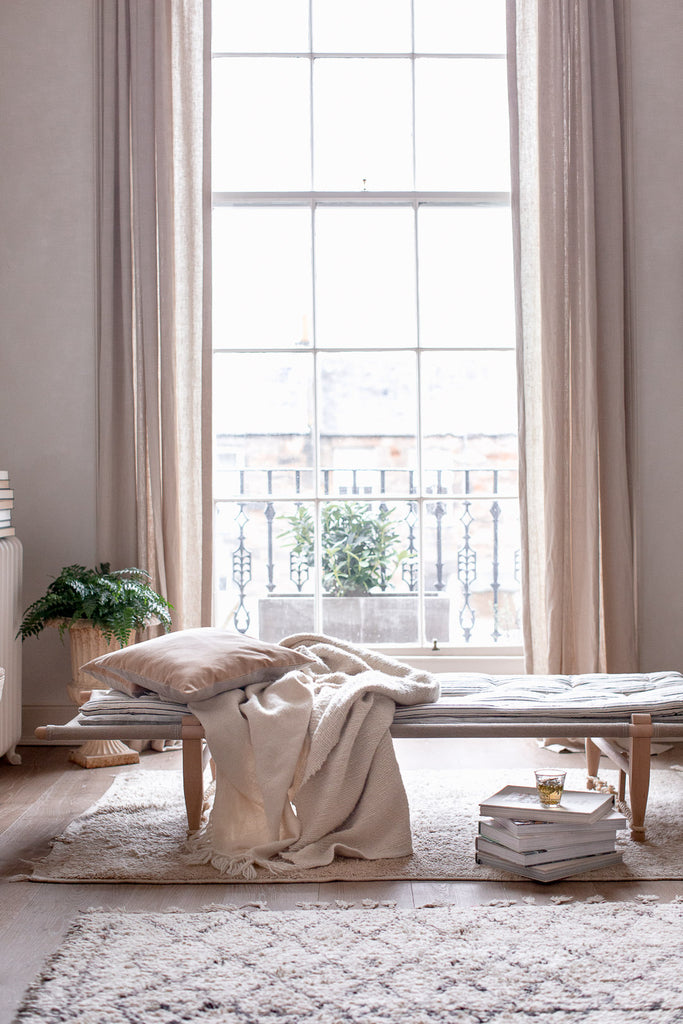 soft cosy daybed by a large window 