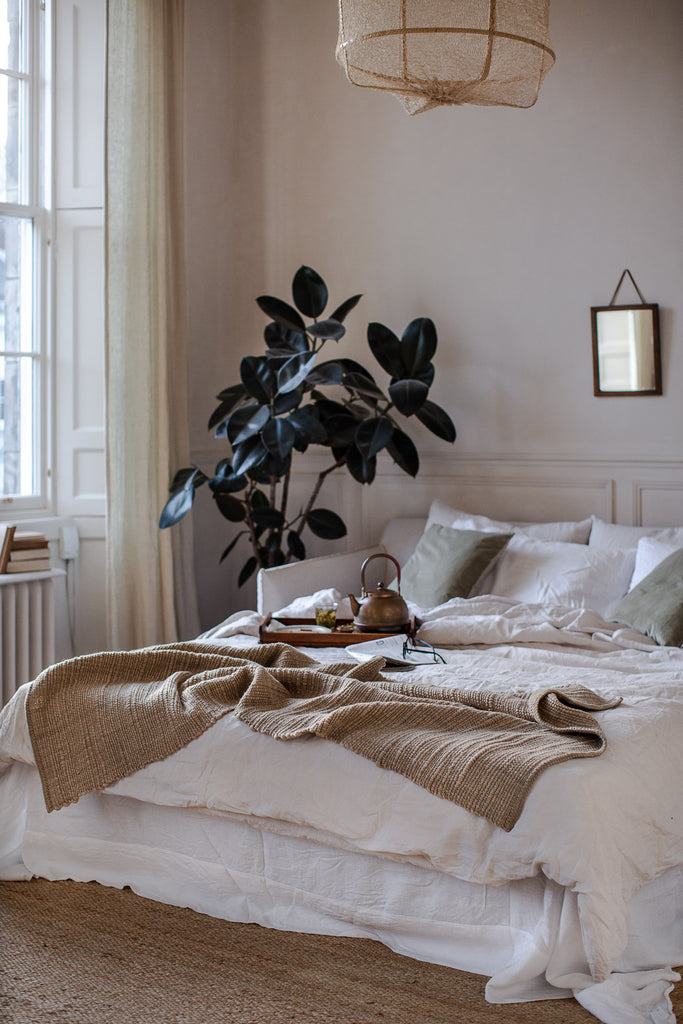 Natural bedroom decor with plants, linen and wool
