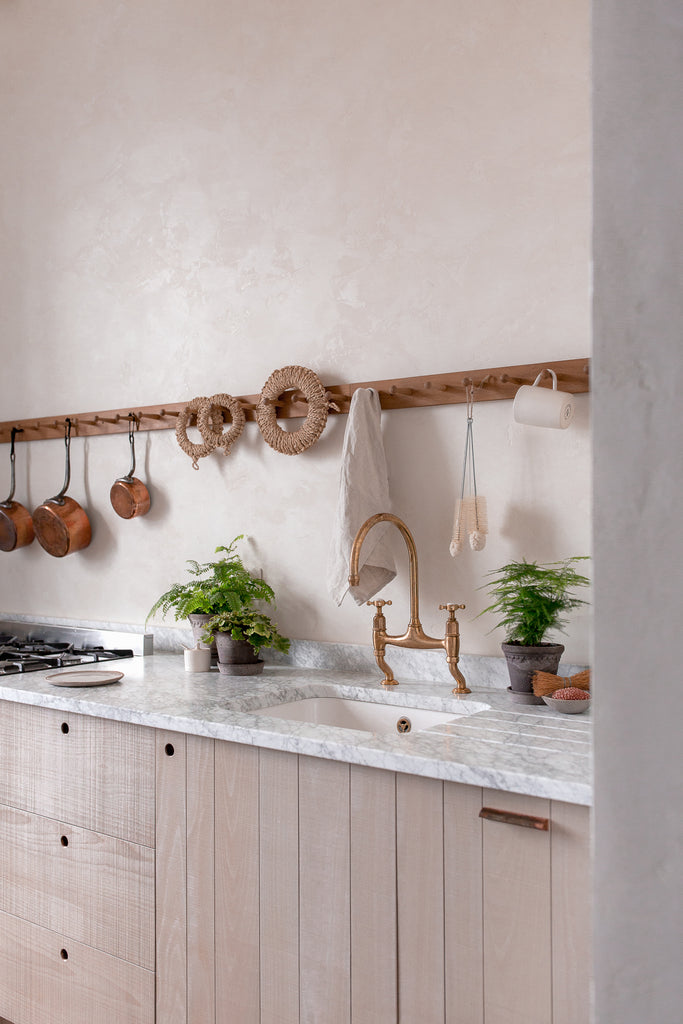 natural wood kitchen with marble work copper brass and plants 