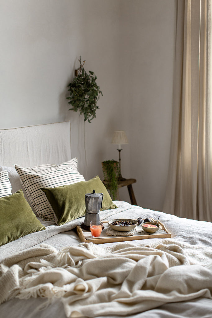 natural bedroom with linen in neutral colours and green 