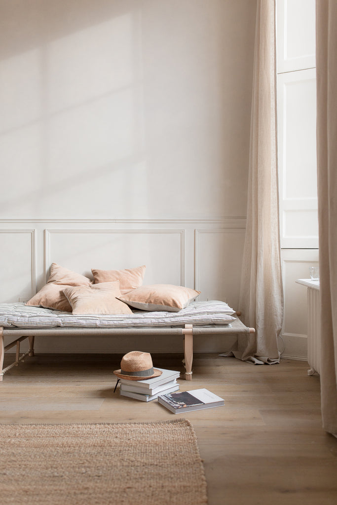 day bed by a large window with velvet cushions