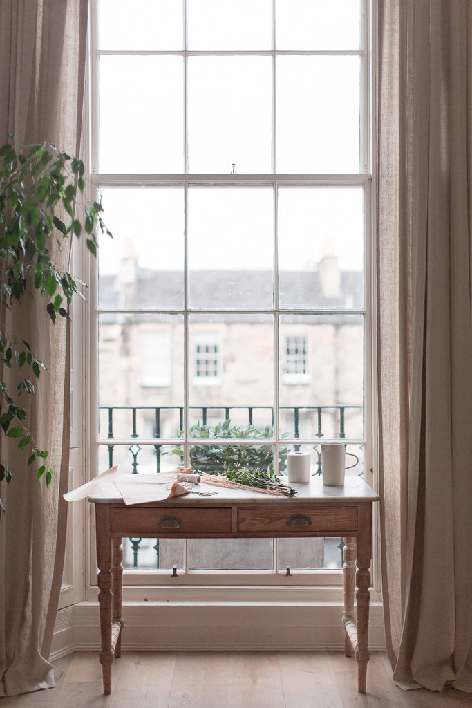 vintage marble and bare wood desk in front of huge window