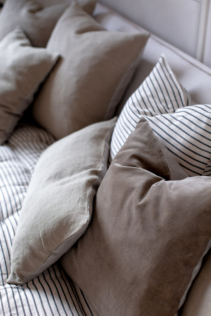 sofa with grey green linen and velvet cushions and stripe cushions 