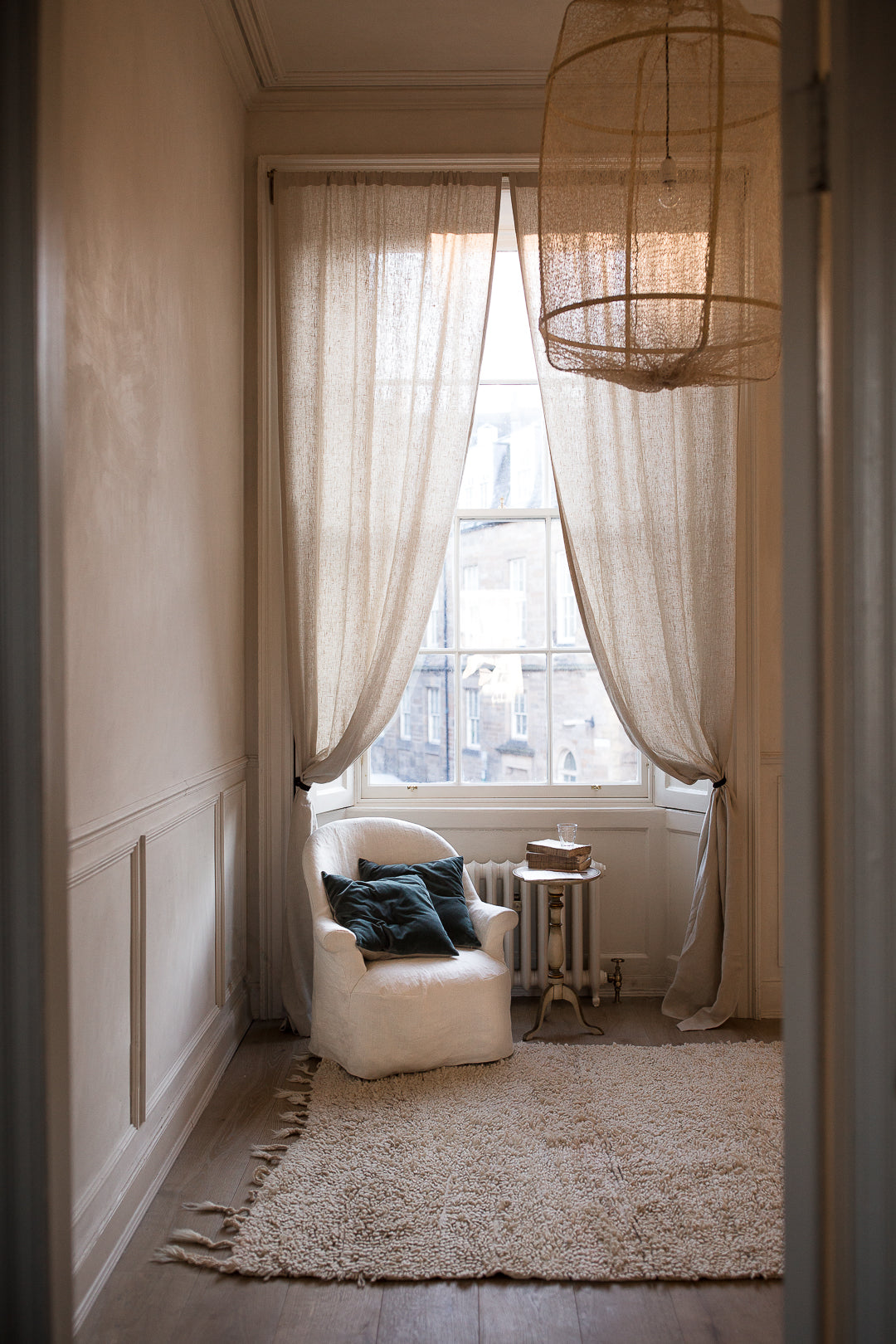 chair with velvet cushions by a large window 