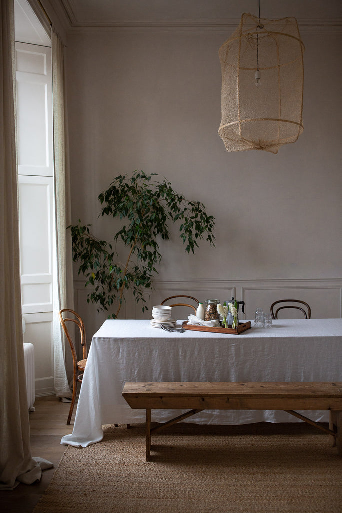 Natural dining room table with linen tablecloth