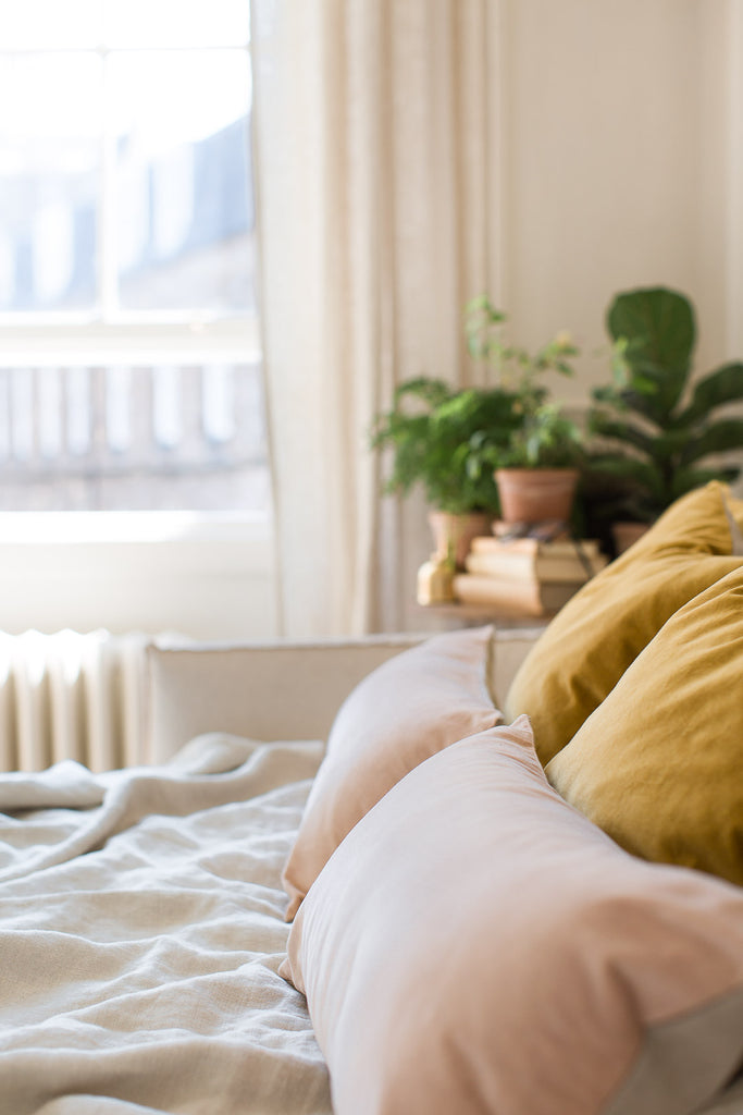 bedroom with mustard yellow and pink velvet cushion covers 