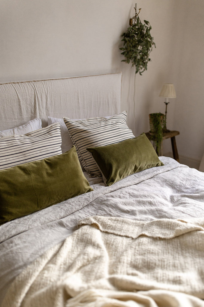 natural bedroom decor in neutral colours with green velvet, linen and wool 
