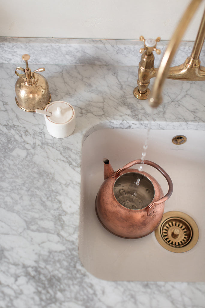 copper kettle with patina on marble worktop 