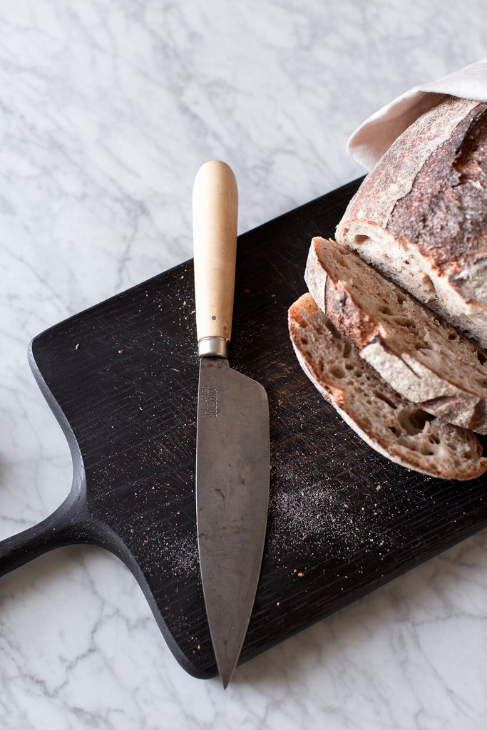 kitchen knife and black wood cutting board