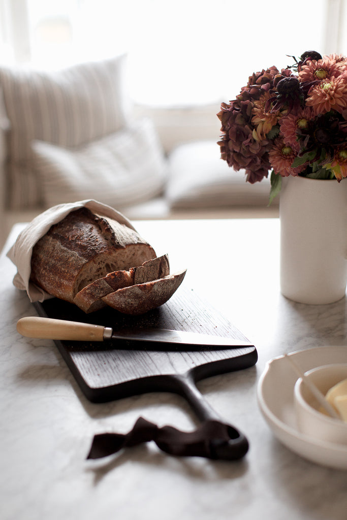 black cutting board, kitchen knife and handmade ceramics 