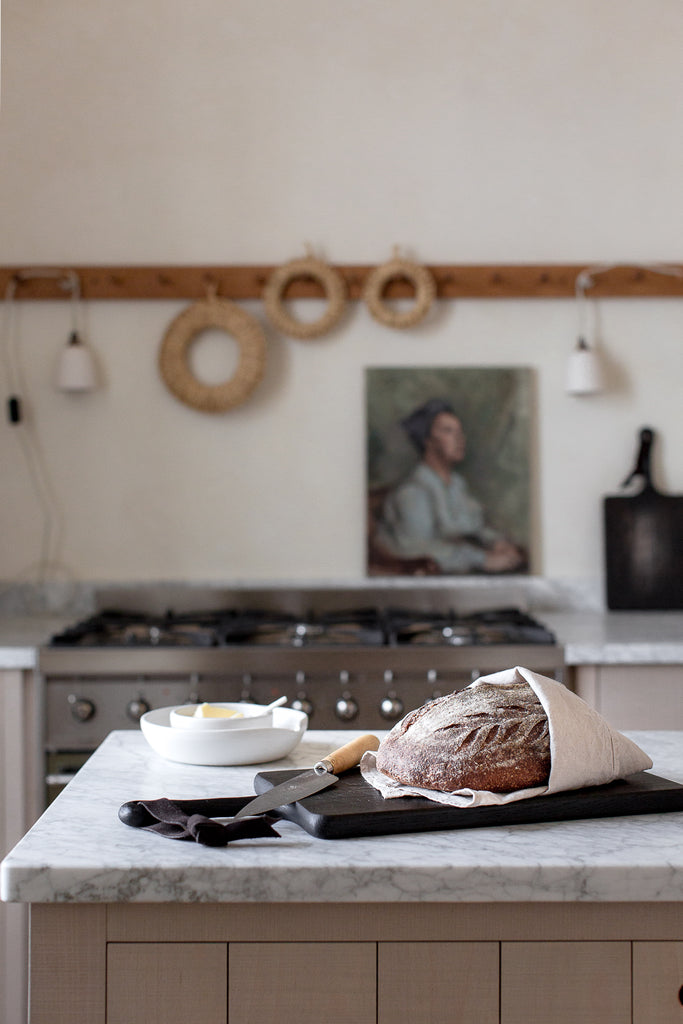 fresh bread on black chopping board on marble 