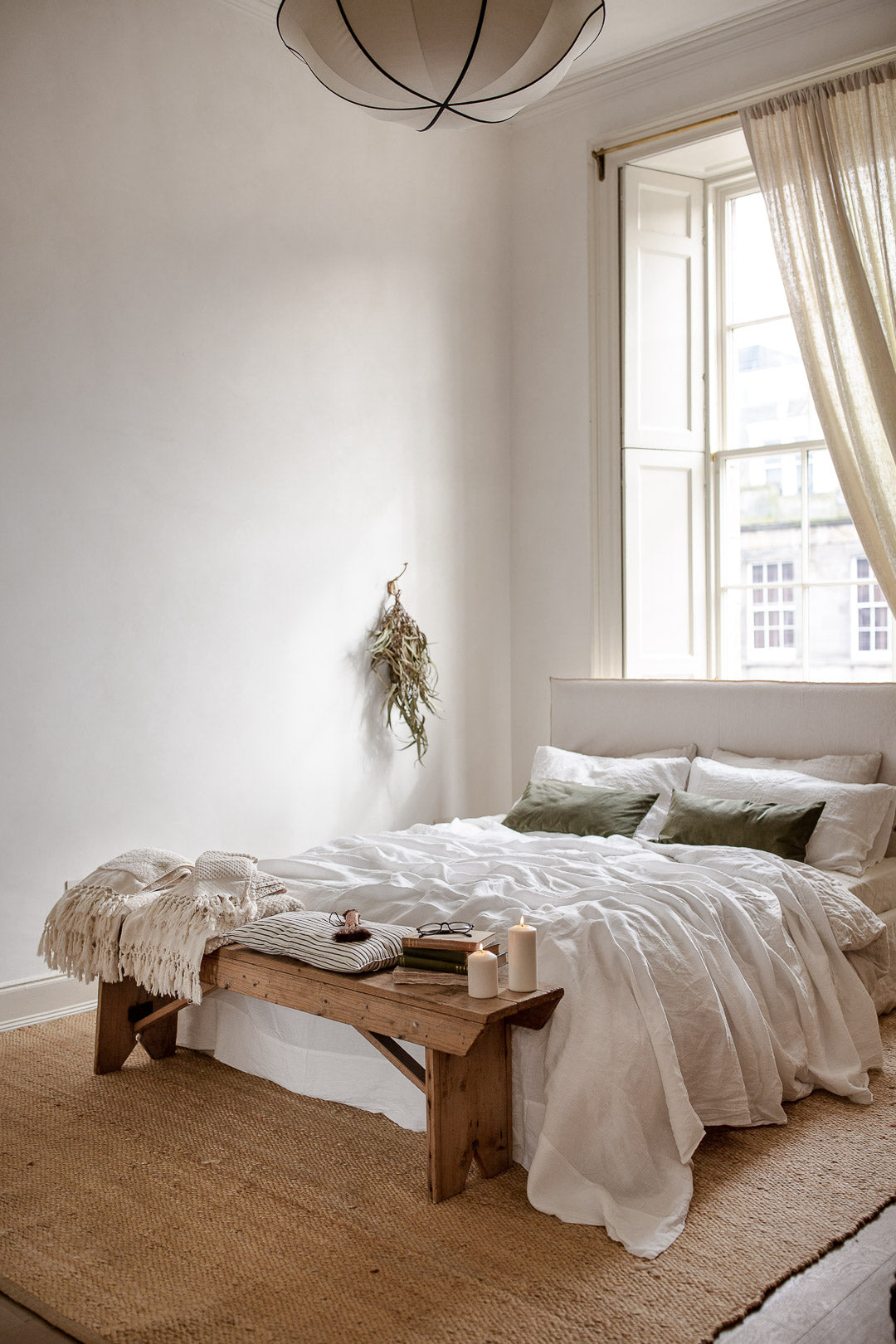 neutral bedroom with linen bedding and jute rug