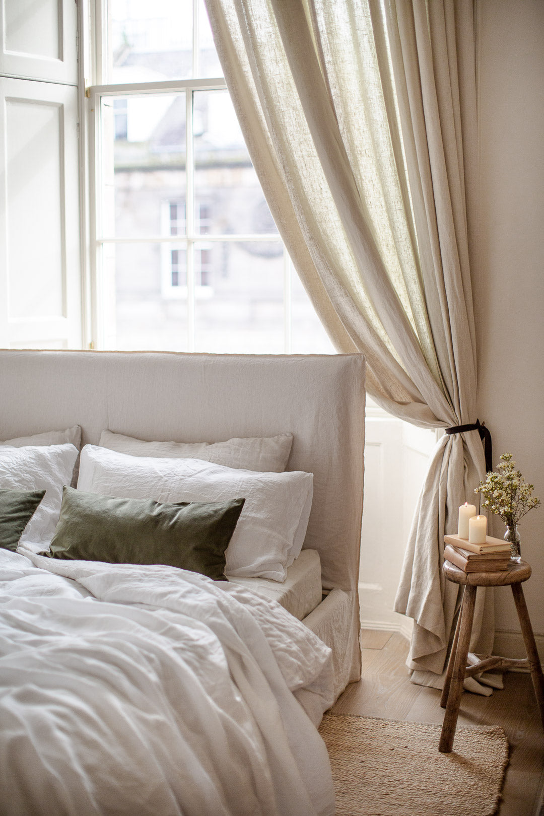 natural bedroom with  cream linen and green velvet 