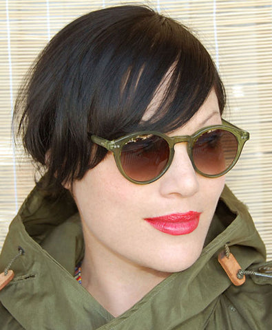 Short haired dark haired girl with red lips sporting her CAMPTOWN green rimmed sunglasses from Giant Vintage