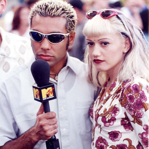 Gwen Stefani standing next to male with microphone sporting her Elodie cat-eyed sunglasses in the color red from Giant Vintage