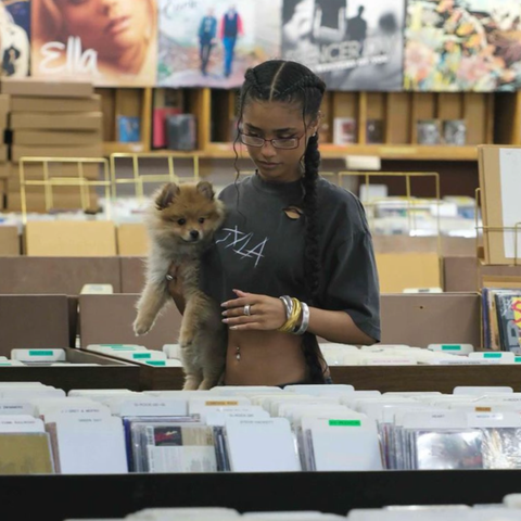 Dark haired girl in a store wearing her LINEAR 90's style glasses from Giant Vintage