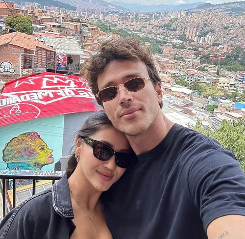 Couple posing next to each other wearing 90's style trendy sunglasses