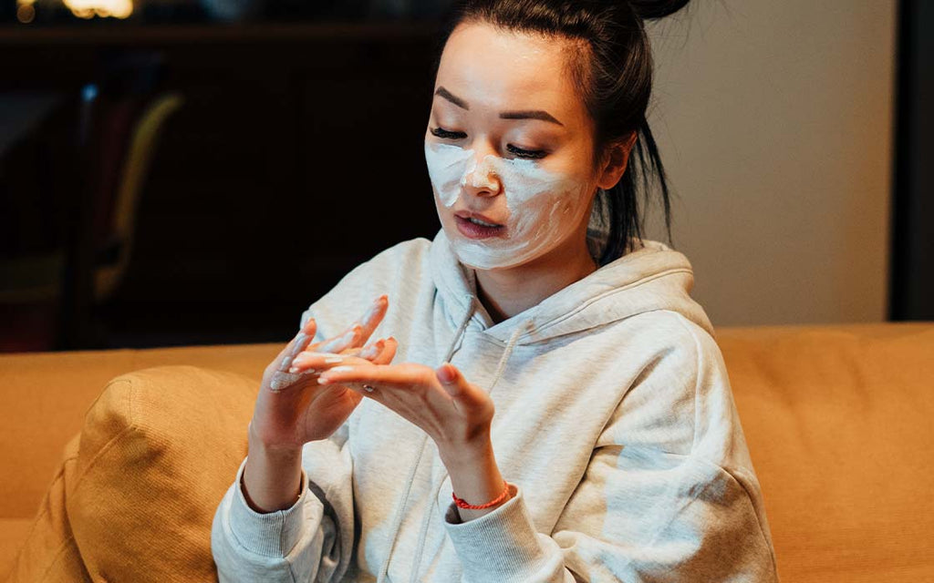 A girl applying skincare on face