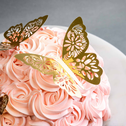 Cake coated with pink swirls, decorated with butterfly cake toppers