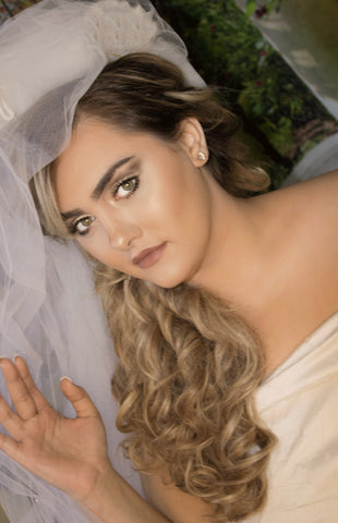 Bride wearing a veil and white wedding dress with long blonde hair extensions by Queen C Hair 