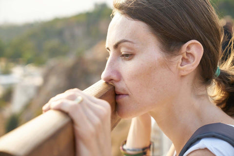 photo of woman looking over a railing in deep thought