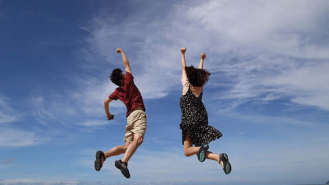 couple jumping up in the countryside