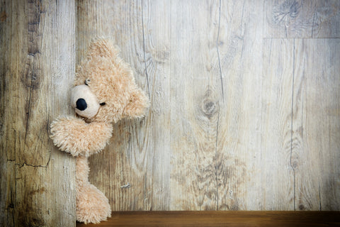 Picture of a teddy bear peek out behind a door