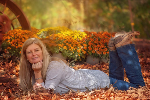 Happy looking woman laying in leaves. After emotional recovery after breast cancer