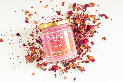 Photo de notre bougie parfumée à la rose anglaise, posée sur un lit de pétales de roses parfumées